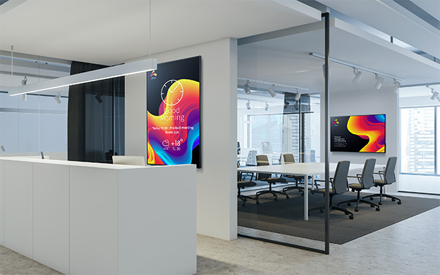 A modern office with welcome signage and presentation screen
